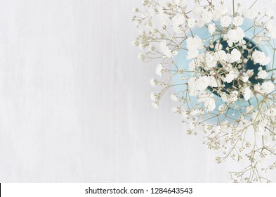 Spring Branch With Small White Flowers In Blue Sphere Vase On White Wood Table Top View, Border.