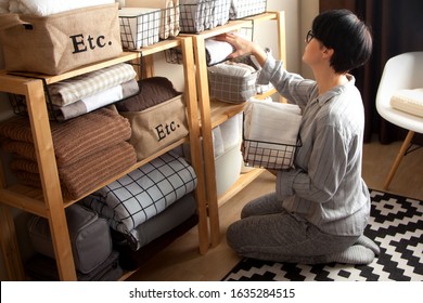 Spring cleaning of closet. Vertical tidying up storage. Neatly folded bed sheets in the metal black baskets for wardrobe. Nordic style. - Shutterstock ID 1635284515