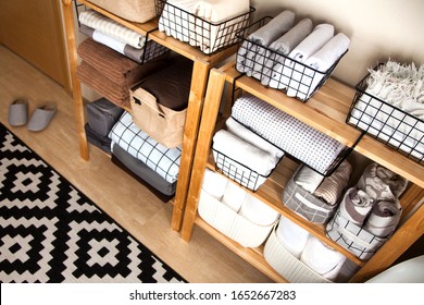 Spring cleaning of closet. Vertical tidying up storage. Neatly folded bed sheets in the metal black baskets for wardrobe. Nordic style. - Shutterstock ID 1652667283