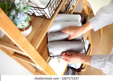 Spring cleaning of closet. Vertical tidying up storage. Neatly folded bed sheets in the metal black baskets for wardrobe. Nordic style. - Shutterstock ID 1687171537