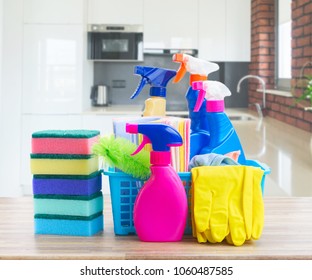 Spring cleaning concept - colorful spays and rubbers on wooden table in white kitchen - Shutterstock ID 1060487585