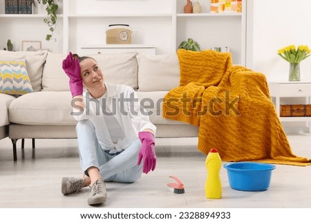 Spring cleaning. Young woman tidying up living room at home