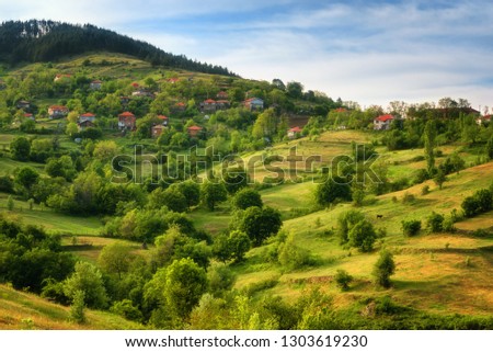 Spring is coming... Amazing spring view with a little village in Rhodopi Mountains, Bulgaria. Magnificent landscape, green fields, small houses - Image