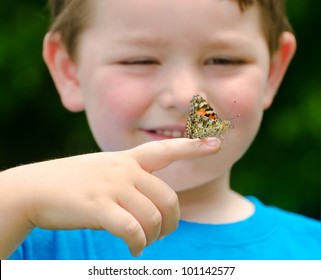 Spring concept with close up of a painted lady butterfly, Vanessa cardui, being held by child playing outdoors in nature - Powered by Shutterstock