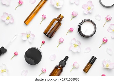 Spring Concept Of Natural Organic Cosmetics. Clean Brown Glass Cosmetic Bottles With Dropper, Cream, Delicate Spring Flowers On White Background Flat Lay Top View. Beauty Herbal Product Spa Aroma Oil