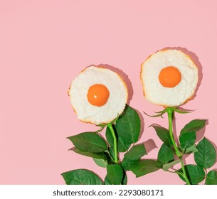 Spring creative layout with fried eggs and rose flower stems on pastel pink background. 80s or 90s retro fashion aesthetic bloom concept. Minimal romantic surreal cosmetic idea.