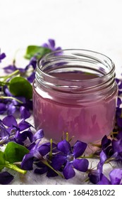 Spring Drinks, Wild Violet Syrup In A Glass Jar, On A Light Background.