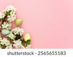 Spring Easter background, multi-colored Easter eggs and blooming apple tree branches on a pink background