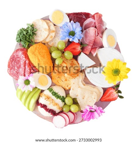 Spring or Easter theme charcuterie board isolated on a white background. Variety of cheese, meat, fruit and vegetable appetizers. Overhead view.