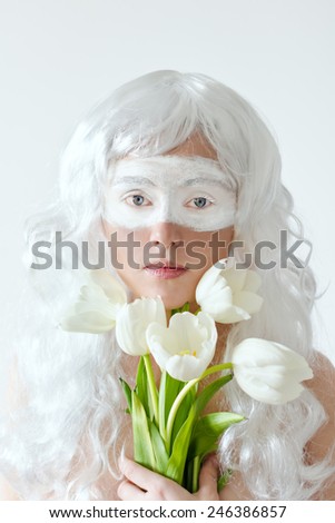 Spring fairy. Young woman in white wig with bouquet of tulips on white background