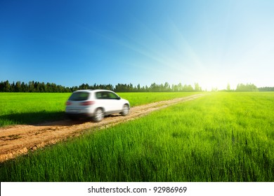 Spring Field And Blured Car On Ground Road