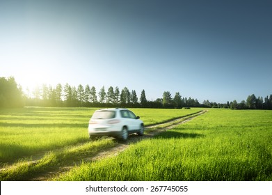 Spring Field And Blurred Car On Ground Road