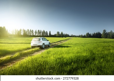 Spring Field And Blurred Car On Ground Road