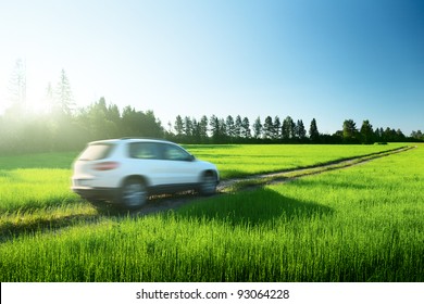 Spring Field And Blurred Car On Ground Road