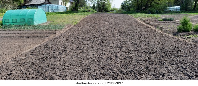 Spring Field In Village Plowed And Prepared For Planting Agricultural Plants. Panoramic Sunny Day Non Urban Landscape