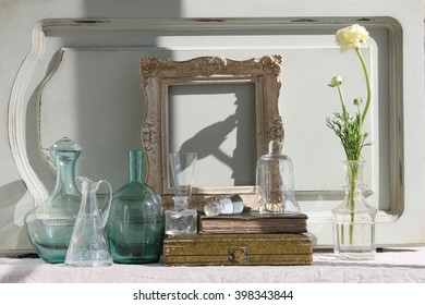 spring flowering glass bottles, vintage group glass, wooden rectangular frame, old books, antique box, fresh white buttercup