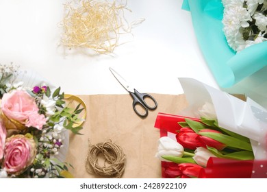 Spring flowers background. Composition with flowers and rope on craft paper. Tulips flowers, scissors and rope on a craft paper background. Vertical. Out of focus. - Powered by Shutterstock