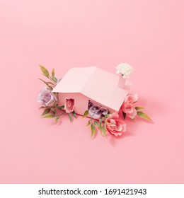 Spring Flowers And Leaves Coming Out Of Pink House. Spring Nature Concept. Season Background Idea.