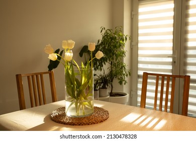 Spring flowers - white tulips in glass vase on wooden table