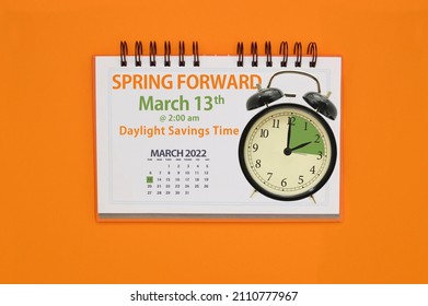 Spring Forward Daylight Savings Time March 2022 Calendar and Clock on orange background