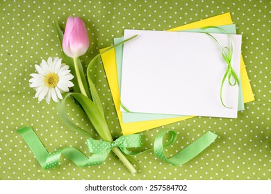 Spring frame for your greeting card with flowers and ribbons in green, yellow and pink