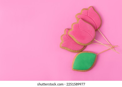 Spring gingerbread with icing on pink background. Space for text. Gingerbreads in the form of a tulips