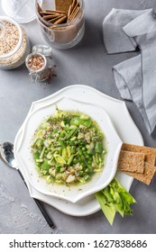 Spring Green Minestrone Soup In A White Plate On A Gray Background, With Whole Grain Breads. Top View Overhead View   Copy Space