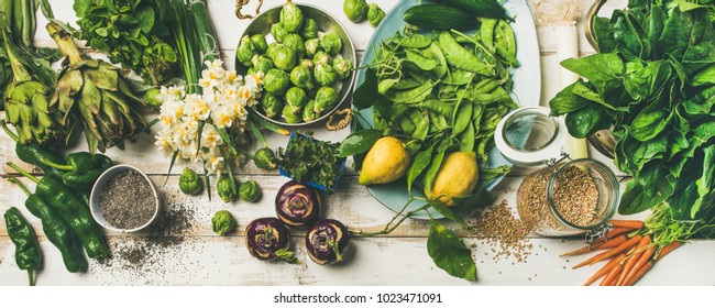 Spring Healthy Vegan Food Cooking Ingredients. Flat-lay Of Vegetables, Fruit, Seeds, Sprouts, Flowers, Greens Over White Wooden Background, Top View. Clean Eating, Diet Food Concept