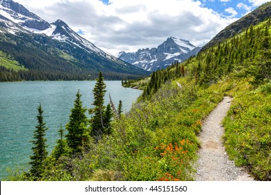 Spring Hiking Trail - A spring view of a hiking trail at shore of Lake Josephine, with Mount Gould and Allen Mountain rising at front and left, in Many Glacier of Glacier National Park, Montana, USA.