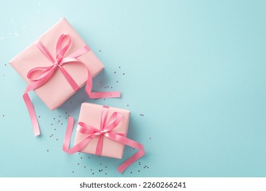 Spring holidays concept. Top view photo of pink gift boxes with ribbon bows and sequins on isolated pastel blue background with copyspace - Powered by Shutterstock