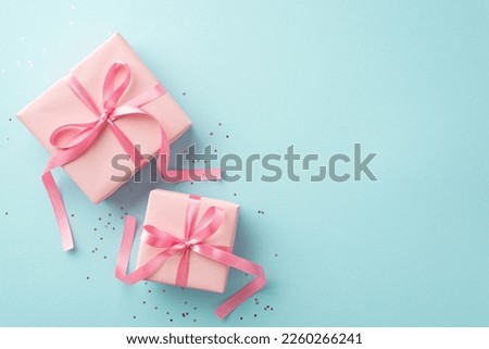 Spring holidays concept. Top view photo of pink gift boxes with ribbon bows and sequins on isolated pastel blue background with copyspace