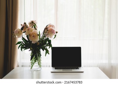 Spring Home Office Still Life Composition. Laptop And Vase With Bouquet White Pink Peonies Flowers On A Table. Cozy Home Office