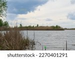 Spring landscape, grassy shore, dark water surface, fishing on the lake. Volgograd region, Volgo reserve - Akhtubinskaya floodplain, Russia