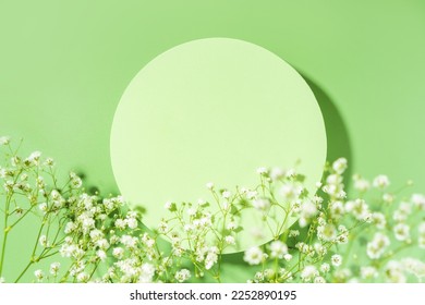 Spring minimal green scene for beauty cosmetic product presentation made with circle geometric shape and wild flowers on a green background. Top view. - Shutterstock ID 2252890195