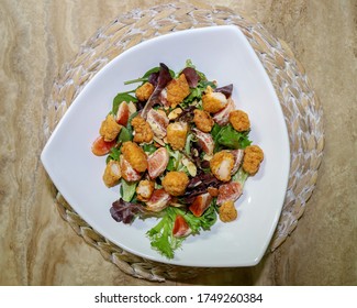 A Spring Mix And Baby Spinach Salad With Breaded Chicken And Blood Mandarin Oranges And Topped With Raspberry Vinaigrette Dressing And  Honey Roasted Almonds. 