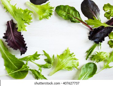 Spring Mix. Fresh Green Salad. Frame Green Salad On Wooden Background With Copy Space