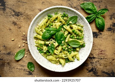 Spring pasta penne with basil pesto and sweet pea in a bowl on a rustic wooden background. Top view with copy space. - Powered by Shutterstock