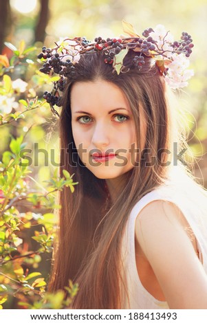 Spring portrait of a beautiful young woman with flower decoration . Sunset light 