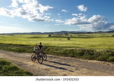 Spring Portrait Of  Happy Young  Couple On A Bike Ride In The Countryside