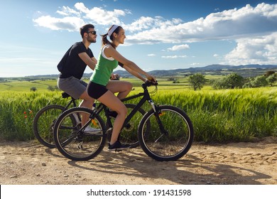 Spring portrait of  Happy young  couple on a bike ride in the countryside