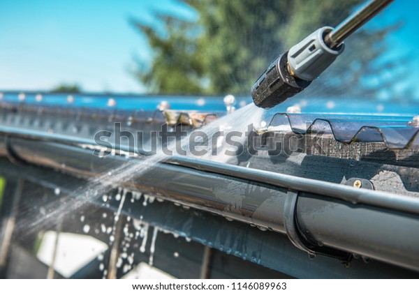 Spring Rain Gutters Cleaning Using Pressure
Washer. Closeup Photo.
