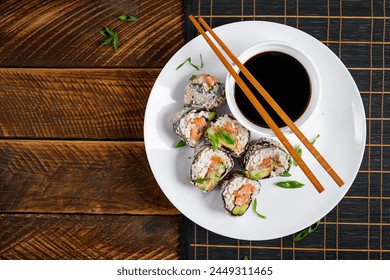 Spring roll with nori, sushi rice, salmon, cucumber and avocado, sriracha and sesame mayonnaise. Top view - Powered by Shutterstock