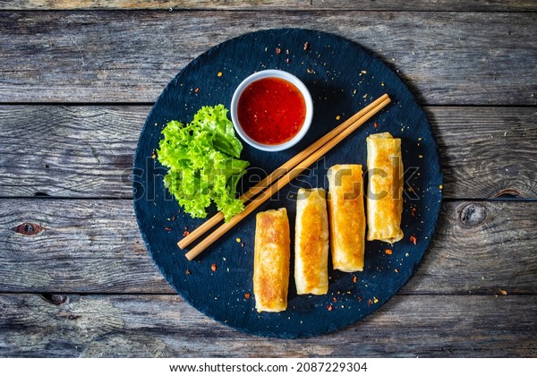 Spring rolls on
stone plate on wooden
table