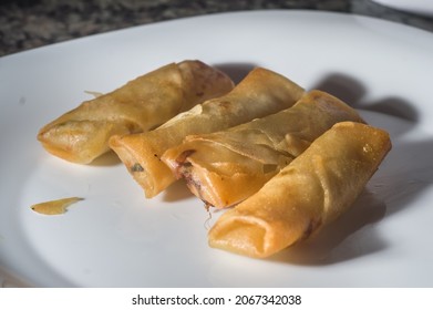 Spring Rolls On A White Brato With Hands Opening A Cheese Roll