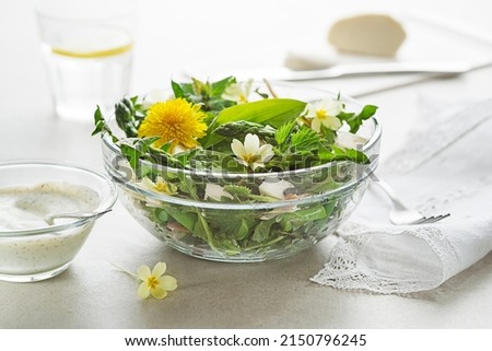 Spring salad with dandelion, asparagus, wild garlic, flowers, nettle and cream cheese. Healthy spring detox food ingredients.