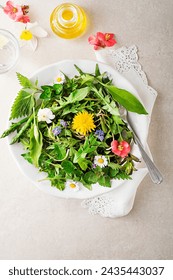 Spring salad with flowers, herbs and plants. Wild garlic, nettle, dandelion and other medicinal herbs and wild edible plants growing in early spring.