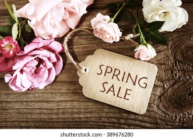 Spring Sale message with small roses on wood background - Shutterstock ID 389676280