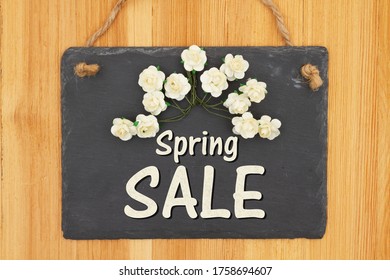 Spring Sale Type Message On A Hanging Chalkboard Sign With White Roses On Wood