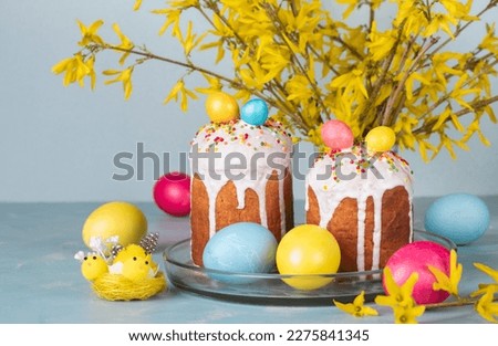 Spring still life of Easter cakes decorated colorful eggs on lightblue background