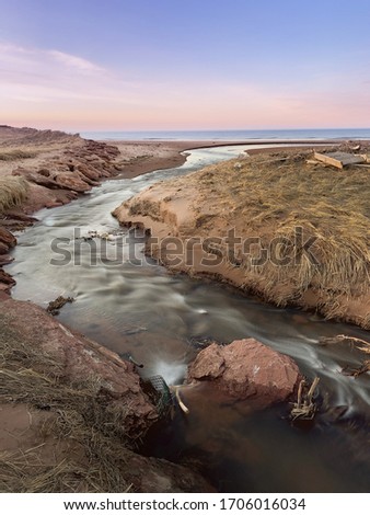 Spring stream flowing from fresh water pond into salt water ocean